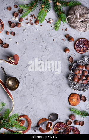 Früchten und Nüssen Weihnachten Essen Frame, getrocknete Orangen mit Haselnüssen und Vintage Besteck. Erhöhte Ansicht, Textfreiraum. Stockfoto