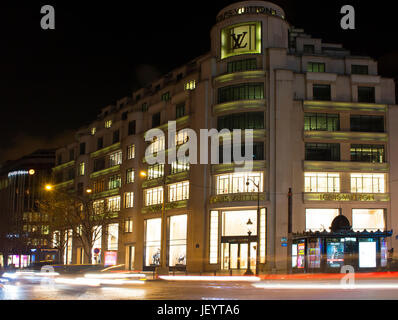 Blick auf berühmte Luxusmarke laden auf dem Boulevard Champs Elysees in Paris. Lichtspuren von Autos in Bewegung Erstellen dynamischer und dramatische Atmosphäre. Stockfoto