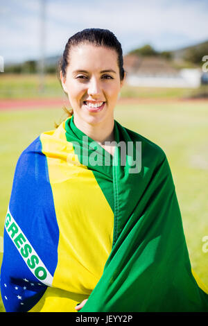 Weibliche Athleten in der brasilianischen Flagge gewickelt Stockfoto