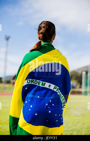 Weibliche Athleten in der brasilianischen Flagge gewickelt Stockfoto