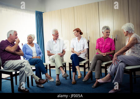 Senioren, die Interaktion mit Krankenschwester Stockfoto