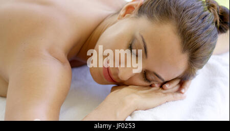 Frau mit Kinn auf gefaltetes Handtuch Lächeln Stockfoto