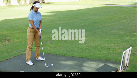 Junge weibliche Golfer Vorbereitung zum Abschlag Stockfoto