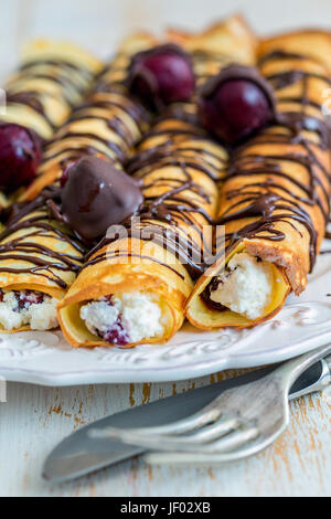 Crêpes mit Frischkäse, Kirschen und Schokolade. Stockfoto