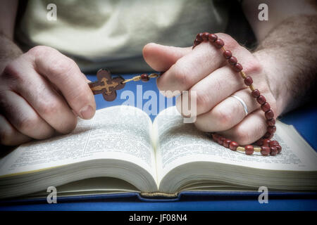 Christliche Gläubige beten zu Gott, mit Rosenkranz in der hand Stockfoto