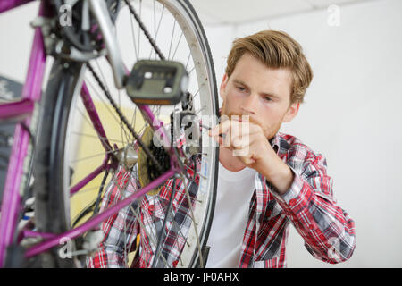 Mann arbeitet am Hinterrad eines Fahrrades Stockfoto