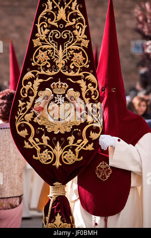 Detail der Büßer hält eine Fahne mit dem Wappen der Bruderschaft während der Karwoche, Andalusien, Spanien Stockfoto