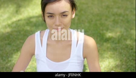 Ruhige junge Frau in weißen Bluse mit Grinsen Stockfoto