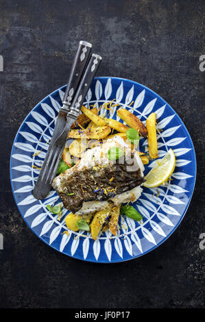 Heilbutt-filet mit Bratkartoffeln auf dem Teller Stockfoto