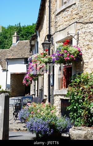 Hübsche Blumen außerhalb The Castle Inn im Dorf Zentrum, Castle Combe, Wiltshire, England, UK, Westeuropa. Stockfoto