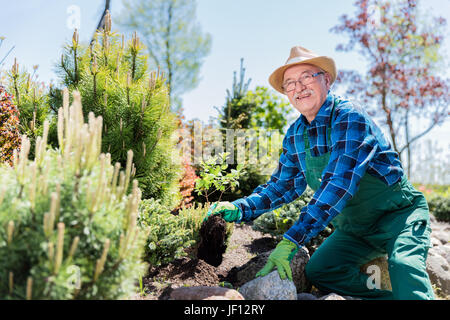 Leitender Gärtner in einem Garten zu graben. Boden vorbereiten für ein neues Werk. Gartenarbeit-Konzept. Stockfoto