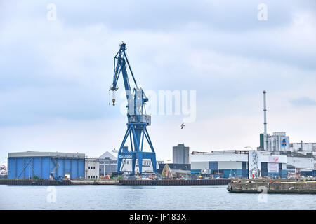 AARHUS (Dänemark)-5. Juni 2016: Portalkran stehend auf dem Kai vor Lagerhallen im Hafen von Aarhus Stockfoto