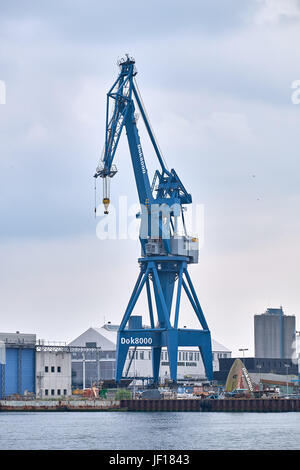 AARHUS (Dänemark)-5. Juni 2016: Portalkran stehend auf dem Kai vor Lagerhallen im Hafen von Aarhus Stockfoto