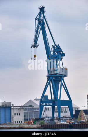 AARHUS (Dänemark)-5. Juni 2016: Portalkran stehend auf dem Kai vor Lagerhallen im Hafen von Aarhus Stockfoto