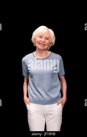 Porträt von stilvollen lächelnde senior Frau isoliert auf schwarz Stockfoto