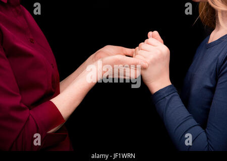 verkürzte Ansicht der Enkel und Oma Hand in Hand isoliert auf schwarz Stockfoto