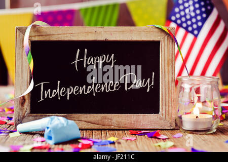 Holz-gestaltete Tafel mit dem Text glückliche Independence Day geschrieben und eine amerikanische Flagge, platziert auf einem rustikalen hölzernen Hintergrund, bestreut mit Stockfoto