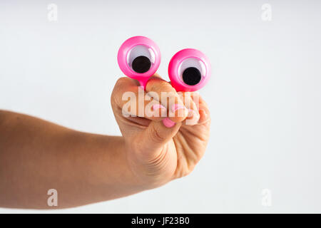 lustiger Charakter Kreatur suchen, verwirrt und Betrachtung, dargestellt mit weiblichen Hand und Googly Augen. Isoliert auf weiss mit Textfreiraum Stockfoto