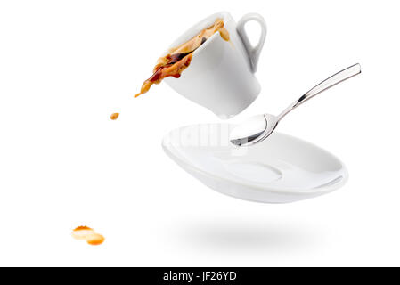 Tasse Kaffee Spils mit Untertasse und Löffel und Kaffee fällt auf weißem Hintergrund Stockfoto