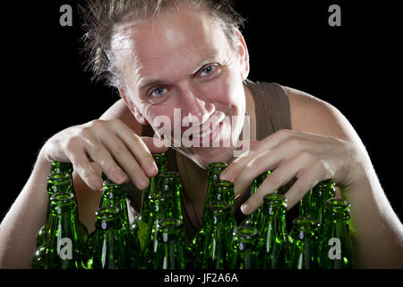 Der glücklich betrunken Mann in der Nähe von leere Bierflaschen Stockfoto