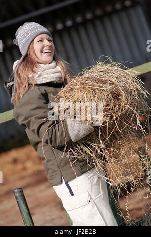 Lächelnde Frau mit Heu Stockfoto