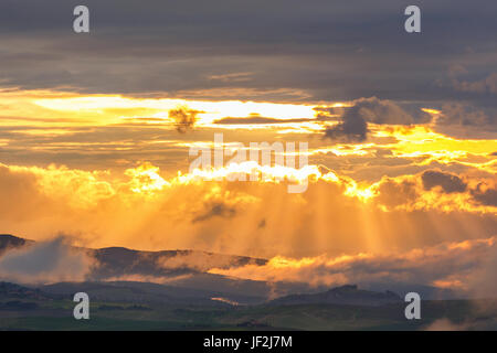 Sonnenuntergang mit Sonnenstrahlen über die sanften Hügel Stockfoto