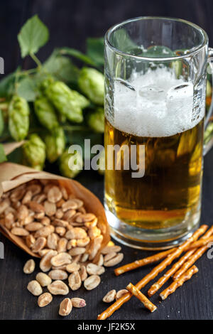 Tüte Erdnüsse und Becher Bier. Stockfoto