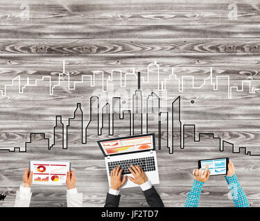 Gruppe von drei Personen mit Geräten in Händen arbeiten zusammen als Symbol der Vernetzung und Kommunikation Stockfoto