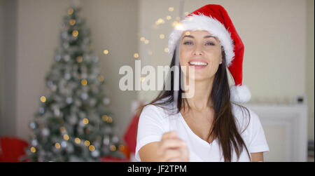 Festliche junge Frau im roten Weihnachtsmann-Mütze Stockfoto