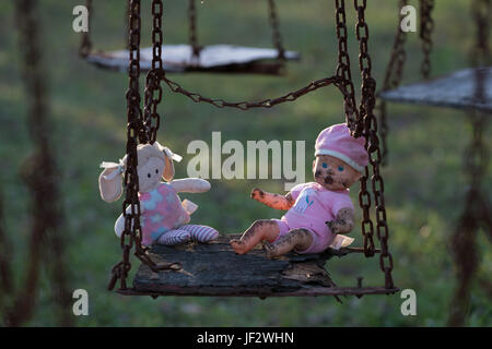 Verlassene Kinder Puppe und Soft Toy auf Swing Stockfoto