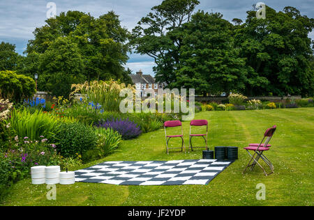 Outdoor Riese Entwürfe oder checkers Spiel in formalen Blumengarten, dirleton Castle, East Lothian, Schottland, Großbritannien, mit Falten Stühle auf Rasen Stockfoto
