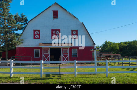 Wand Townsip, NJ USA--26. Juni 2017 rote und weiße Scheune hinter einer weißen Lattenzaun auf der Allaire Community Farm. Nur zur redaktionellen Verwendung. Stockfoto