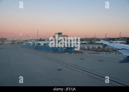 FRANKFURT, Deutschland - 20. Januar 2017: Flugzeuge, ein Airbus von Lufthansa, an der Pforte im Terminal 1 des Frankfurt International Airport FRA während des Sonnenuntergangs. Terminal 1 wurde im Jahr 1972 fertiggestellt und beherbergt Lufthansa und anderen Star Alliance-Partnern Stockfoto