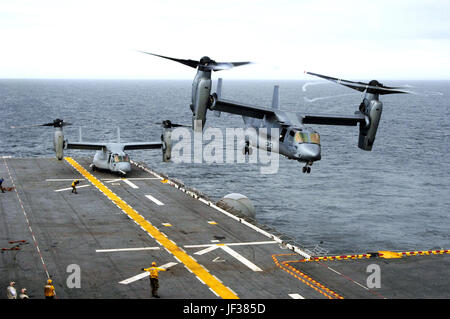 051115-N-3527B-068 ein U.S. Marine Corps MV-22 Osprey führt eine vertikale ausziehen aus dem Flugdeck der amphibischen Angriff Schiff USS Wasp (LHD-1) als ein weiterer wartet im Flugbetrieb im Atlantischen Ozean am 15. November 2005 zu starten.  Der Fischadler ist eine fortschrittliche Technologie, vertikaler/kurzer Start und Landung Mehrzweck taktische Flugzeuge und die Alterung CH-46E Sea Knight und CH-53D Sea Stallion-Hubschrauber derzeit im Dienst ersetzen soll.  Diese Fischadler sind Marine Tiltrotor Operational Test und Auswertung Geschwader 22 der Marine Corps Air Station New River, N.C. zugewiesen Stockfoto