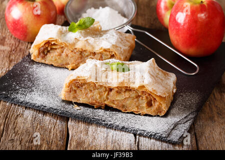 Köstliches Stück Apfelstrudel mit Puderzucker und Minze Closeup auf einem Tisch. horizontale Stockfoto