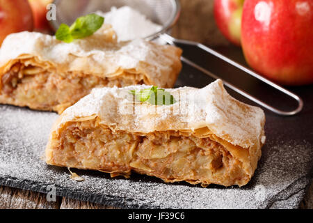 Österreichische Küche: Apfelstrudel mit Puderzucker Zucker und Minze Closeup auf dem Tisch. Horizontale Stockfoto