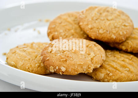 Krümelig Hafer-Kekse (Cookies) auf einen weißen Porzellanteller mit Krümel sichtbar. Stockfoto