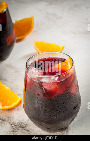 Traditionelle spanische Sommer erfrischenden Drink, Cocktail, Tinto de Verano. Mit Wein, Eis und Stücke von frischem Orange. Am weißen Stein Tisch kopieren Sie Raum Stockfoto