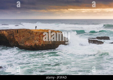 Fotograf auf einer Klippe in der Point Arena an der felsigen pazifikküste Nordkaliforniens. Sturm kommt aus dem Westen erzeugt hohe Brandung. Stockfoto