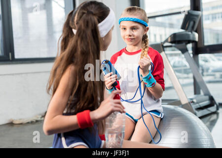 zwei kleine Mädchen in der Sportswear sitzen im Fitness-Studio, Kinder-sport-Konzept Stockfoto