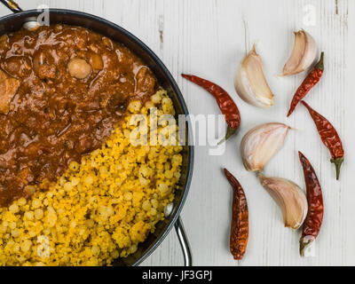 Lamm-Tajine mit Couscous und Kichererbsen vor einem weißen Hintergrund Stockfoto