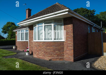 Ein roter Backstein-Bungalow mit Erker an einem sonnigen Tag. Shropshire, UK Stockfoto