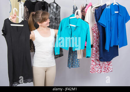 Mädchen wählt Kleider in ihrem Kleiderschrank Stockfoto