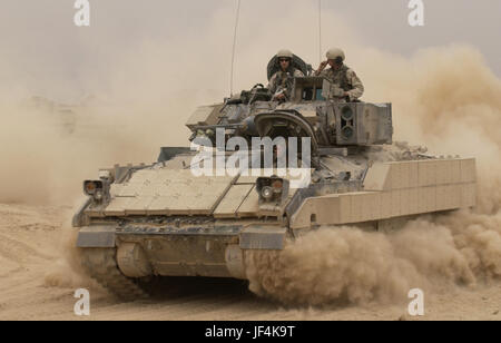 041030-F-2034C-040 ein M2A2 Bradley Fighting Vehicle kicks bis Federn von Staub, wie es Forward Operating Base MacKenzie im Irak für eine Mission auf 30. Oktober 2004 lässt.  Die Bradley wird Alpha-Truppe, 1. Bataillon, 4. Kavallerie-Regiment, 1st Infantry Division zugewiesen.  DoD-Foto von Staff Sgt Shane A. Cuomo, US Air Force.  (Freigegeben) Stockfoto