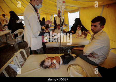 Ein kleines Yemenite Kind, der verdächtigt wird, mit Cholera infiziert wird in einem Zelt außerhalb eines Krankenhauses in Sanaa, Jemen, 28. Juni 2017 behandelt. Die Vereinten Nationen (UN) Gesundheit Agentur sagt, es gibt jetzt mehr als 200.000 mutmaßliche Fälle von Cholera in einem Ausbruch in Krieg-heftig gezerrissenes Jemen, viele davon sind Kinder. Foto: Hani Al-Ansi/dpa Stockfoto