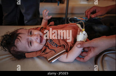 Ein kleines Yemenite Kind, der verdächtigt wird, mit Cholera infiziert wird in einem Zelt außerhalb eines Krankenhauses in Sanaa, Jemen, 28. Juni 2017 behandelt. Die Vereinten Nationen (UN) Gesundheit Agentur sagt, es gibt jetzt mehr als 200.000 mutmaßliche Fälle von Cholera in einem Ausbruch in Krieg-heftig gezerrissenes Jemen, viele davon sind Kinder. Foto: Hani Al-Ansi/dpa Stockfoto