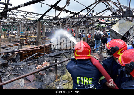 Dhaka, Bangladesch. 29. Juni 2017.  Bangladeshi Feuerwehrleute versuchen, das Feuer zu löschen, während ein Brandes mehrere Schuppen an Gabtoli Viehmarkt in Dhaka, Bangladesch, 29. Juni 2017 entkernt. Rund 13 wurden Kühe und 26 Ziegen getötet, als der Markt um 10:00 Donnerstag gefangen Feuer. Bildnachweis: SK Hasan Ali/Alamy Live-Nachrichten Stockfoto