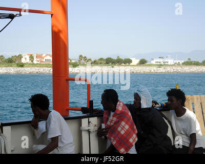 Corigliano Calabro, Italien. 29. Juni 2017.   Migranten blicken in trockenes Land während des Anfluges auf den Hafen von Corigliano Calabro, Italien, 29. Juni 2017. Die Hilfsorganisationen Ärzte ohne Grenzen und SOS Méditerranée brachte sie nach Italien, nach dem Speichern sie aus Seenot. Foto: Lena Klimkeit/Dpa/Alamy Live-Nachrichten Stockfoto