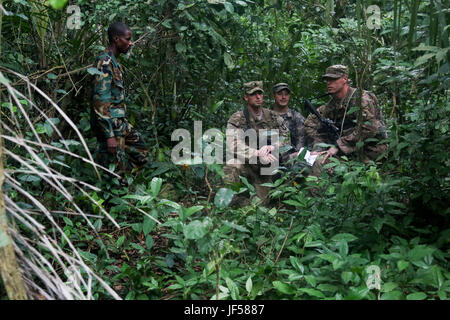 Ghana bewaffnete Kräfte Sgt. Kofi Francis Donkor beobachtet, wie US-Soldaten der 1. zugewiesen Bataillon, 506. Infanterieregiment, 1st Brigade Combat Team, 101. US-Luftlandedivision navigieren Sie durch den Dschungel während United Accord 2017 bei Jungle Warfare School auf die Militärbasis Achiase, Akim Oda, Ghana, 26. Mai 2017. Jungle Warfare School ist eine Reihe von situative Übungen entwickelt, um Teilnehmer zur Niederschlagung von Aufständen und interne Sicherheitsmaßnahmen zu trainieren. (Foto: U.S. Army Sergeant Brian Chaney) Stockfoto