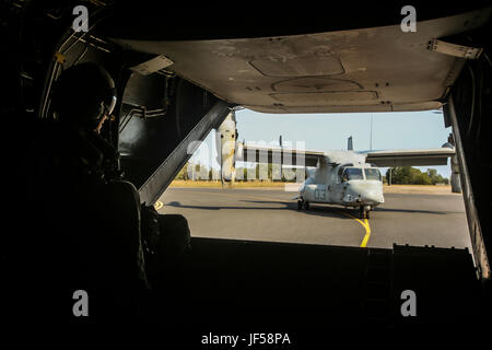 ROYAL AUSTRALIAN AIR FORCE BASE DARWIN, Australien--US Marine Sgt. Phil Berry, Waffen und Taktiken Instruktor, Marine Medium Tiltrotor Squadron 268, Marine Rotations Kraft Darwin, schaut hinten ein MV-22 Osprey, wie sie von der Landebahn, 26. Mai 2017 Rollen. Dies ist der Fischadler ersten Einsatz nach Australien und die Interoperabilität Ausbildungskapazitäten für die Australian Defence Force und der US-Marines hinzugefügt hat. Berry, 28 Jahre alt, ist von Annapolis, Maryland (U.S. Marine Corps Foto von Sgt. Emmanuel Ramos) Stockfoto